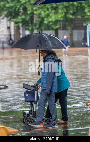 Preston Lancashire.  UK Weather 22 July 2023. Summer sales, shops, and shoppers on a rainy day in the city centre. Forecasters say: 'Rain, heavy at times, through Saturday & Sunday is likely to cause some disruption, particularly to outdoor events. Credit: MediaWorldImages/AlamyLiveNews Stock Photo