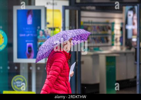 Preston Lancashire.  UK Weather 22 July 2023. Summer sales, shops, and shoppers on a rainy day in the city centre. Forecasters say: 'Rain, heavy at times, through Saturday & Sunday is likely to cause some disruption, particularly to outdoor events. Credit: MediaWorldImages/AlamyLiveNews Stock Photo