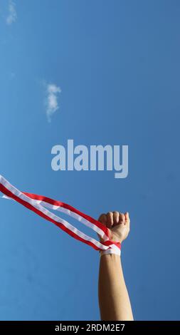 Hand with red and white ribbon, Indonesian independence day celebration concept Stock Photo