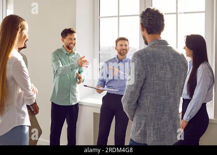 Smiling diverse colleagues brainstorming and discussing new project together Stock Photo