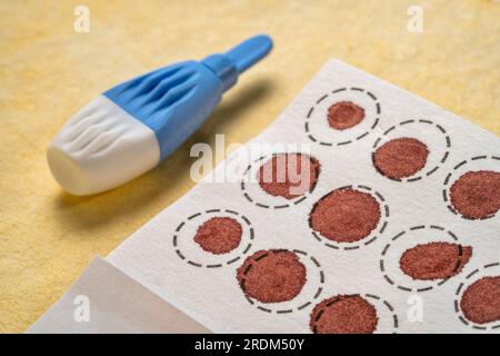 lancet and dry blood spots on a fiber filter for laboratory analysis, home health testing concept Stock Photo