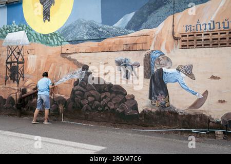 Thailand, Phang Nga, Takua Pa March 2, 2023 . Street photo, art on the wall. Peasants harvest rice, watering Stock Photo