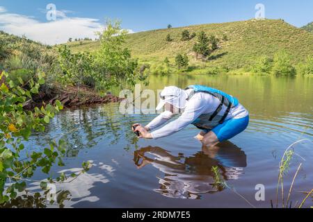 senior male paddler wearing life jacket with a wooden canoe paddle on a ...