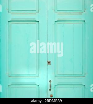 Plain wooden door painted pastel turquoise color. Stock Photo