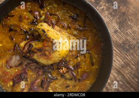 A chicken fillet and wing on the bone that have been homecooked and curried with brown lentils to make a chicken dal. England UK GB Stock Photo