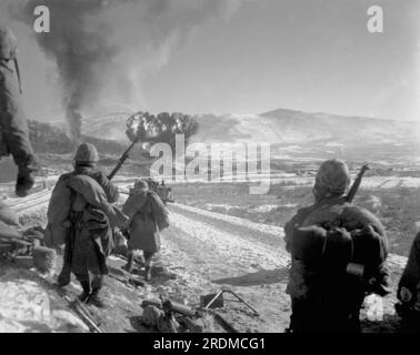 HAGARU-RI, KOREA - 26 December 1950 - US Marines move forward after effective close-air support flushes out the enemy from their hillside entrenchment Stock Photo