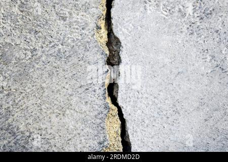 Big crack on old plastering wall. Vertical winding crack in surface of an old building. Copy space. Selective focus. Stock Photo