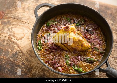 A chicken fillet and wing on the bone that have been homecooked and curried with brown lentils to make a chicken dal. England UK GB Stock Photo