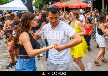 Toronto, Canada - July 19, 2023: A dancing couple amid other people in the street. Salsa on Saint Clair St. West Festival is a popular annual event in Stock Photo