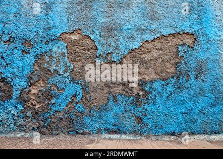 Beautiful weathered blue wall with graphic texture and patterns of flaking plaster and paint, architecture detail of an authentic old town district. Stock Photo