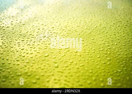 Graded yellow surface covered in small water droplets. Stock Photo