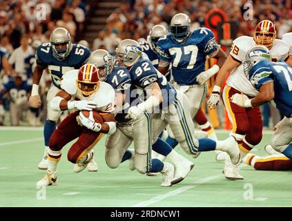 Atlanta Falcons linebacker Robert Lyles (54) pulls on the jersey of  Washington Redskins running back Earnest Byner (21) during first quarter  NFL Divisional playoff action, Jan. 4, 1992, at RFK Stadium in