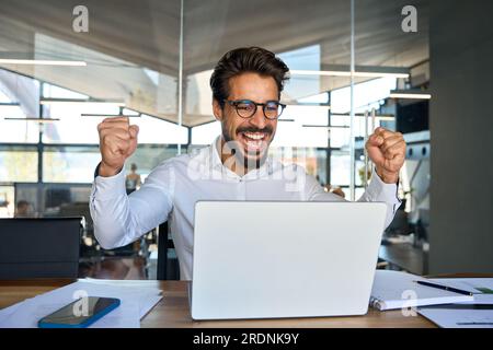 Happy business man celebrating professional achievement in office. Stock Photo