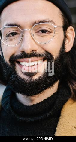 Portrait of positive young hipster man smiling at camera Stock Photo