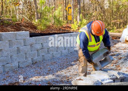 Construction worker is currently working on building retaining wall while constructing wall retaining in new property. Stock Photo