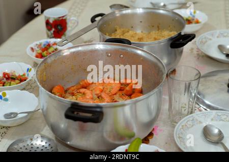 food table with Egyptian rice cooked on hot steam and cooked shrimps with cumin, lemon and onion, a crustacean (a form of shellfish) with an elongated Stock Photo