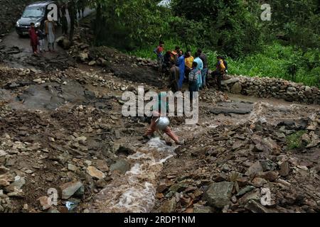 Srinagar, Kashmir. 22nd July 2023. July 22, 2023, Srinagar Kashmir, India :A woman crosses a damaged road following flash floods in the Faqir Gujri area, on the outskirts of Srinagar. Locals claimed that several houses developed cracks and corn fields were damaged, however no casualty was reported. Continuous heavy rains have been battering various regions of Jammu and Kashmir, resulting in multiple landslides in the hilly areas, and leading to the closure of the Jammu-Srinagar National Highway. Credit: Eyepix Group/Alamy Live News Stock Photo