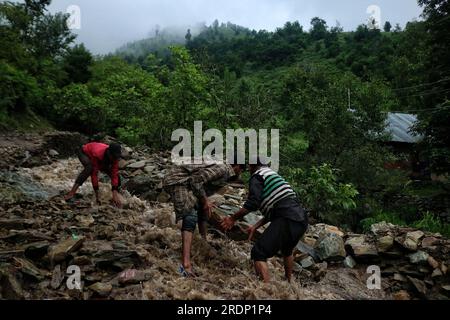 Srinagar, Kashmir. 22nd July 2023. July 22, 2023, Srinagar Kashmir, India : People remove stones to clear the way following flash floods in the Faqir Gujri area, on the outskirts of Srinagar. Locals claimed that several houses developed cracks and corn fields were damaged, however no casualty was reported. Continuous heavy rains have been battering various regions of Jammu and Kashmir, resulting in multiple landslides in the hilly areas, and leading to the closure of the Jammu-Srinagar National Highway. Credit: Eyepix Group/Alamy Live News Stock Photo