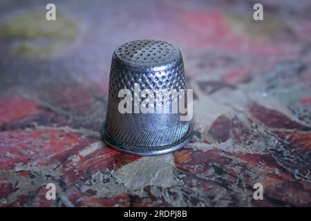 Metal thimble for sewing. Antique copper thimble on a stone background. Stock Photo