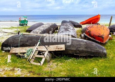 Currachs, traditional Irish fishing boats, lying upturned on Inisheer beach, the smallest of Aran Islands, Galway Bay, Republic of Ireland. Stock Photo