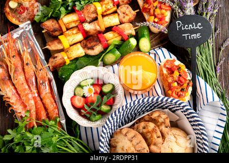 Various of grilled meal - grilled meats, vegetables, fruits, salad and potatoes on a dark wooden background. Top view. Stock Photo