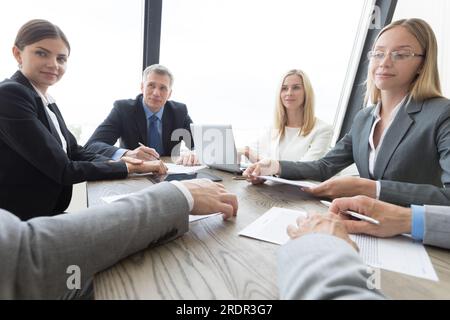 Meeting of business partners using laptops and talking at the table Stock Photo