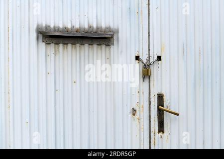 Old worn industrial metal gate with chain and padlock as background Stock Photo