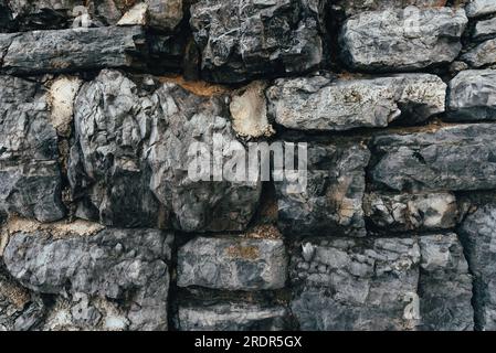 Old gray stone wall as background, texture of a worn facade from Opatija, Croatia. Stock Photo