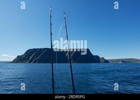 The northernmost tip of Europe large and dramatic rock cliff of North Cape and two fishing rods on summer day on Mageroya island in Finnmark in Northe Stock Photo