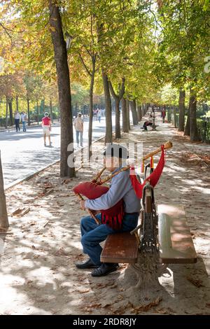 Man playing bagpipes and people strolling  in the Retiro Park, Madrid, Spain. Stock Photo