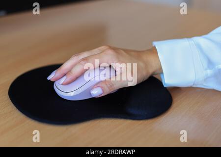 Female hand with computer mouse on table, closeup Stock Photo