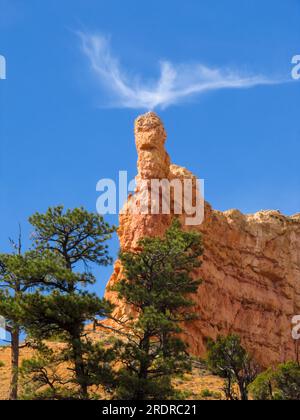 A small Cirrus cloud atop a tower like hoodoo in Bryce Canyon National Park, Utah, looking almost like a chimney Stock Photo