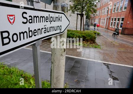 Kiel, Germany. 23rd July, 2023. A sign with the inscription 'Sammelpunkt Bombenräumung' stands in front of the collective accommodation in the Hans-Christian-Andersen-Schule. On Sunday, two unexploded bombs, an American 500-kilo bomb and a British 250-kilo bomb from World War II, will be defused on Kiel's eastern shore in Werftpark. Credit: Frank Molter/dpa/Alamy Live News Stock Photo