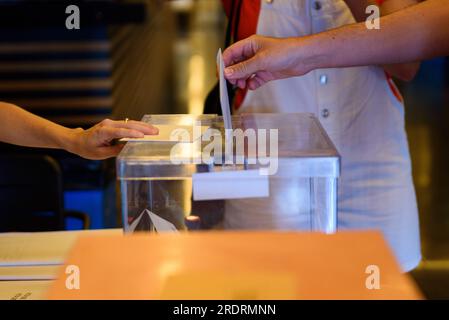 Barcelona, Spain. 23rd July, 2023. In this close up a hand is seen putting the electoral card in a voting ballot at a polling station during Spain's 2023 general elections. Early elections, held for the first time during summer season, were called by President Pedro Sanchez and see a left wing coalition comprised by the PSOE and Sumar parties challenged by the right wing block consisting of the Popular Party (PP) and far right party Vox. More than 37 millions Spanish citizens are called to the ballots. (Photo by Davide Bonaldo/Sipa USA) Credit: Sipa USA/Alamy Live News Stock Photo