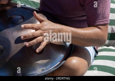 Man playing a percussion instrument called a handpan. Tibetan sounds. Stock Photo