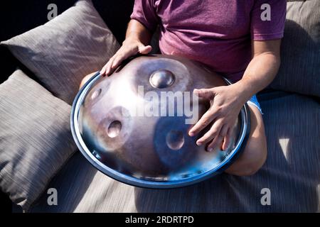 Man playing a percussion instrument called a handpan. Tibetan sounds. Stock Photo