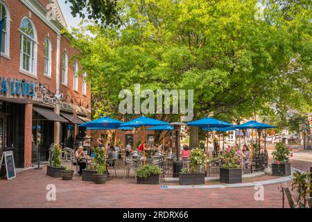 Newburyport, MA, US-July 13, 2023: Street scene in small town downtown with 19th century brick buildings, trendy shops and outdoor restaurants. Stock Photo