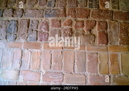 Close-up of an old brick-paved farm interior. Clay brick paving pattern. The ancient cobblestone brick floor is also called brick pavement. Latvia Bau Stock Photo