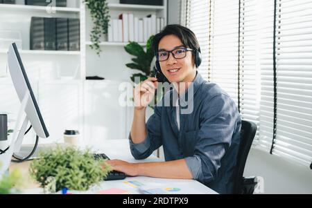 Portrait of customer service operator with headsets working at call centre, Call center agent with headsets working on support hotline in modern Stock Photo