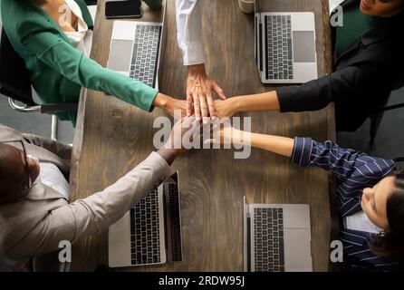 Top View Of Diverse Coworkers Joining Hands In Office Stock Photo