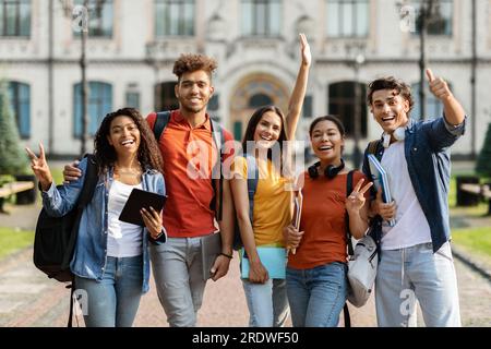 Freshmen Orientation. Group Of First Year Students With Workbooks Posing Together Outdoors Stock Photo