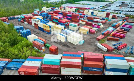 Aerial stacked walls of metal shipping crates in container yard Stock Photo