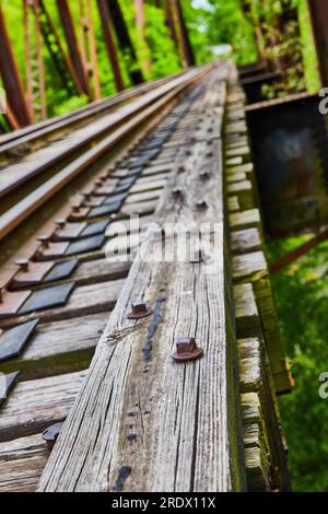 Blurred background of railroad bridge with nuts and bolts on textured wooden train track beam Stock Photo