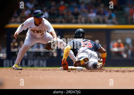 Milwaukee Brewers' Willy Adames, right, places a cheesehead hat on