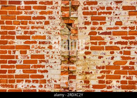 Background asset red bricks with white decay and busted ones poking out from middle of wall Stock Photo