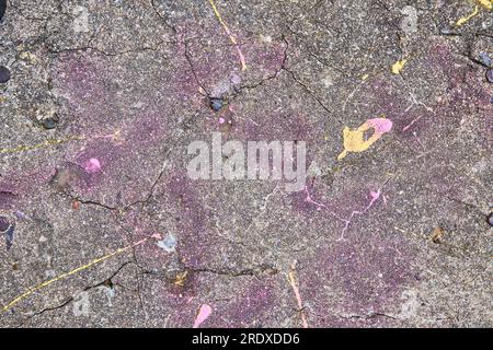 Concrete wall textured with faint pink and purple spray paint and yellow paint blob Stock Photo