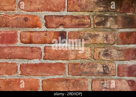 Cracked and dirty or grimy red brick wall background asset Stock Photo