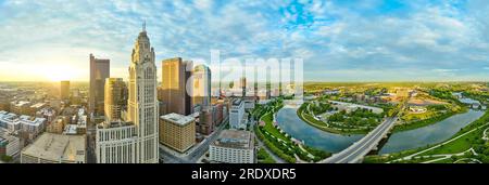 Panorama aerial with downtown skyscrapers on one side and city on the other side at sunrise Stock Photo