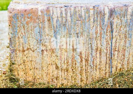 Textured concrete with blue chemical burn streaking down multicolored side background asset Stock Photo