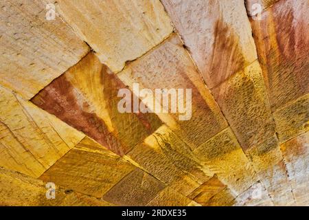 Tilted shot of curved wall of golden and earth tone brick wall abstract background asset Stock Photo